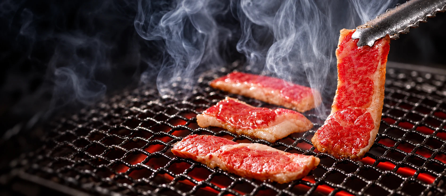 Beef sizzling on an electric yakiniku grill with rising smoke